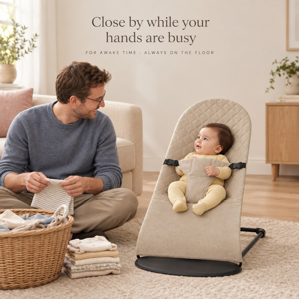 Baby in the bouncer on the floor beside dad folding laundry - for awake time, always on the floor