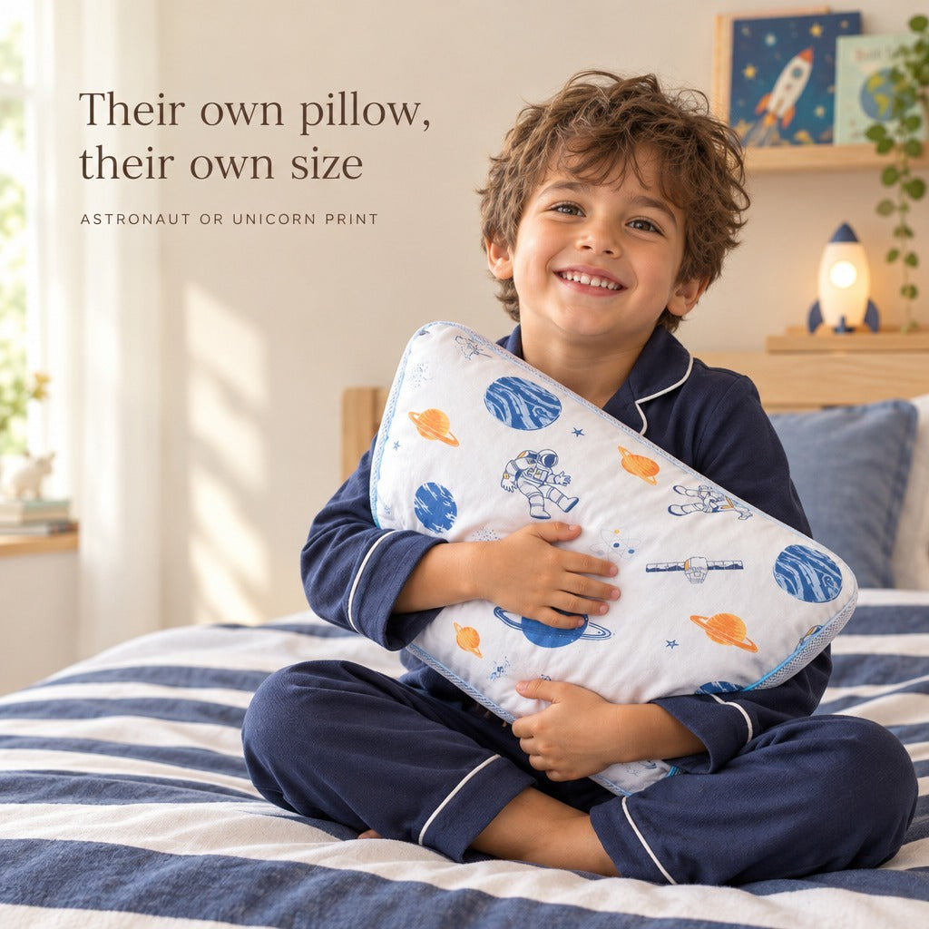Boy in pyjamas hugging his astronaut print kids pillow - their own pillow, their own size