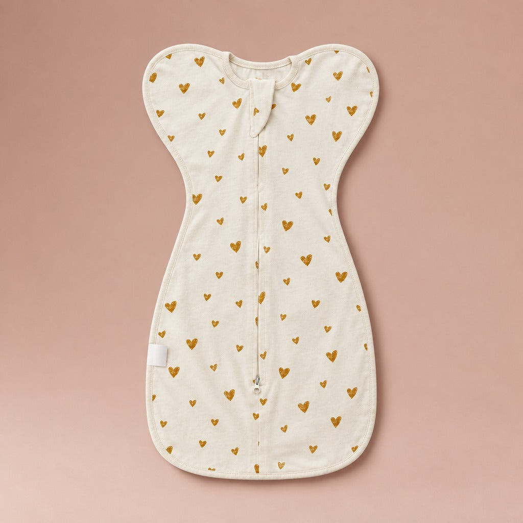The Petal Swaddle arms-up swaddle sleep sack with zip in Gold Hearts