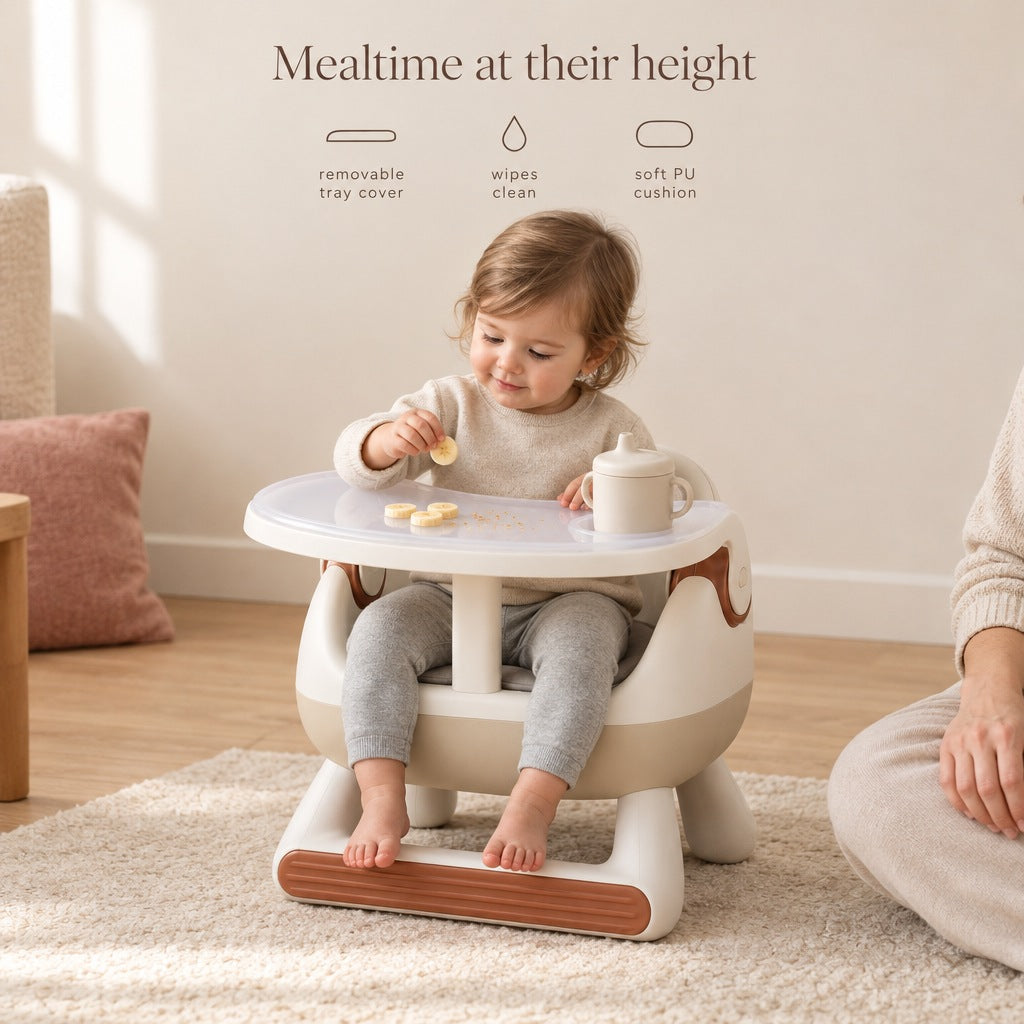 Toddler eating a snack in the low chair on the floor - removable tray cover, wipes clean, soft PU cushion
