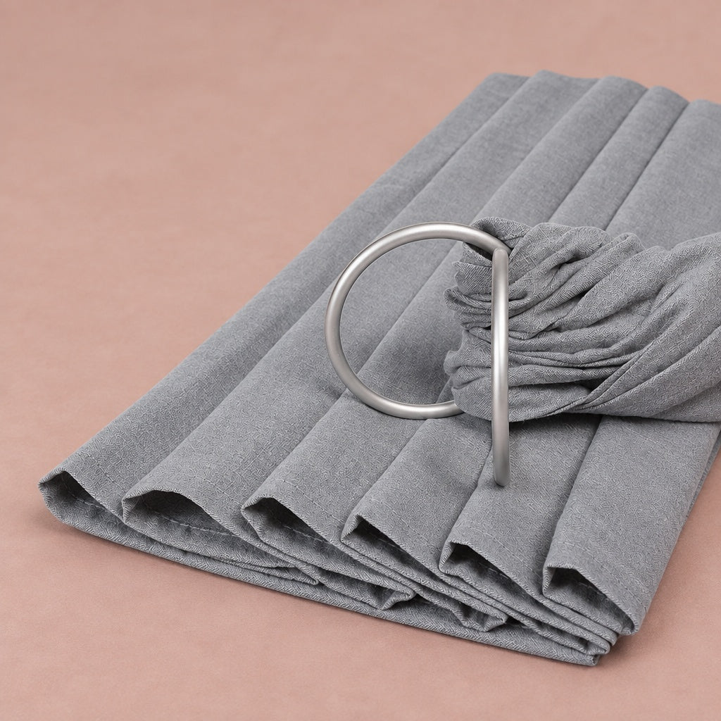 Grey baby ring sling folded, with its two matte silver rings