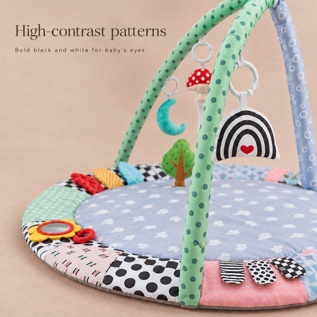 High-contrast black and white patterns on the play gym mat and rainbow toy