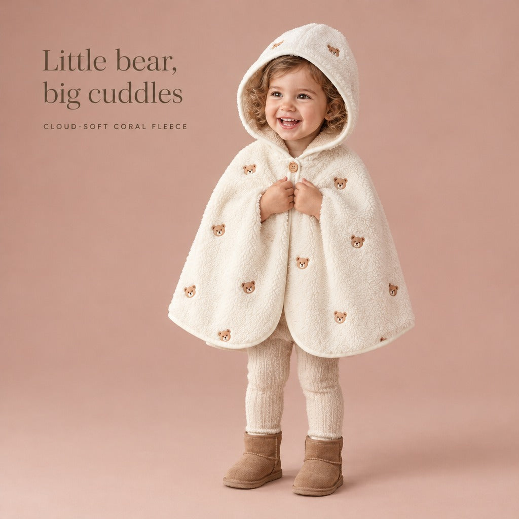 Toddler girl laughing in The Teddy Mantle fleece cape with the hood up — Little bear, big cuddles