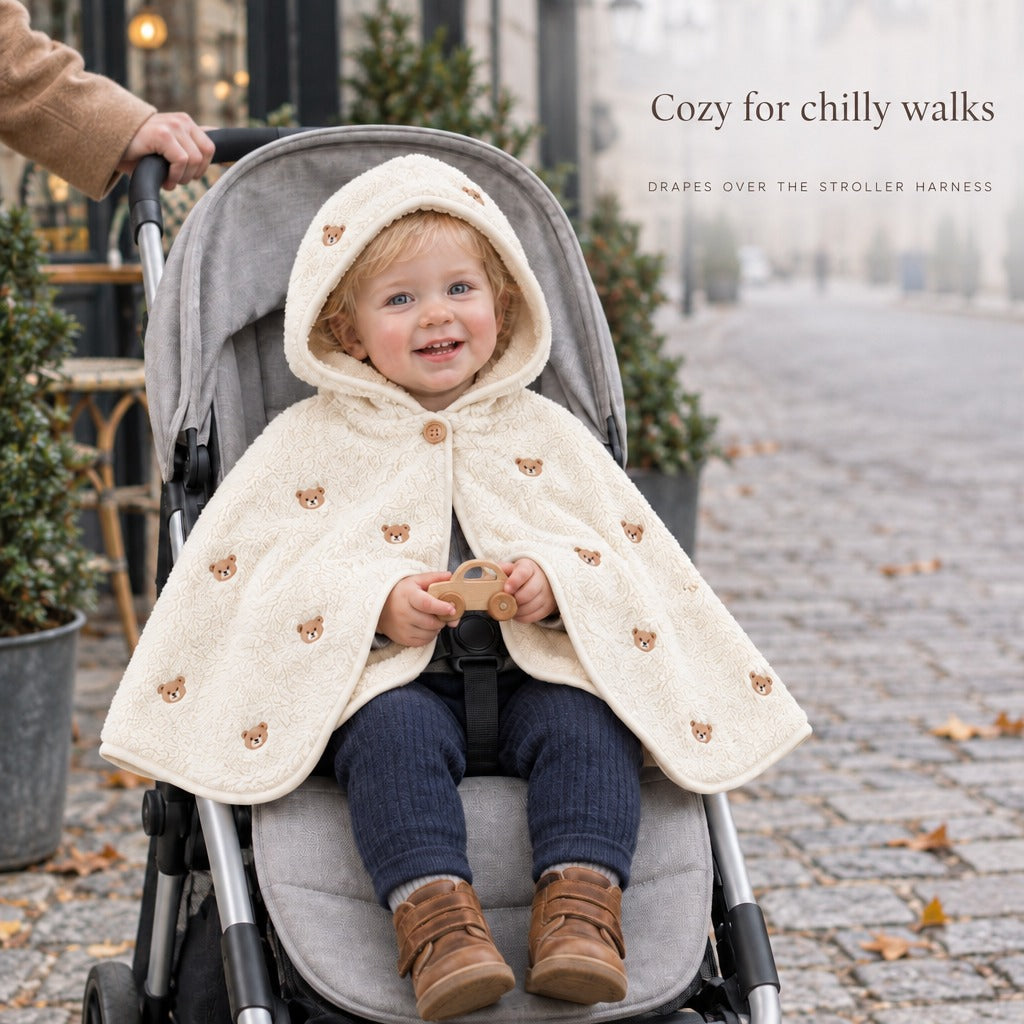 Toddler in a stroller with The Teddy Mantle draped over the harness — Cozy for chilly walks