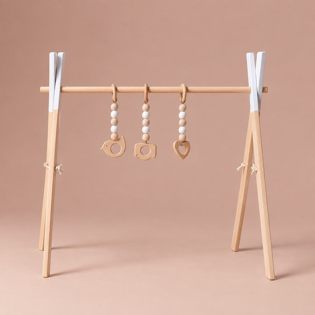 Wooden baby play gym with white painted tops and three hanging toys