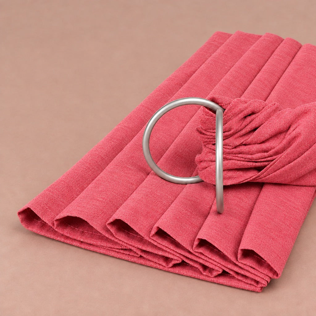 Rose linen-blend baby ring sling folded, with its matte silver rings