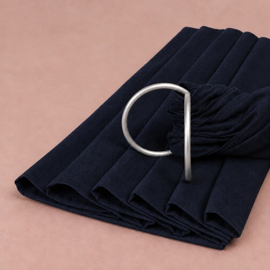 Black linen-blend baby ring sling folded, with its matte silver rings